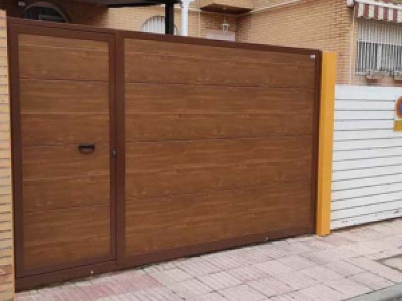 Puertas seccionales color madera y puerta de acceso a vivienda